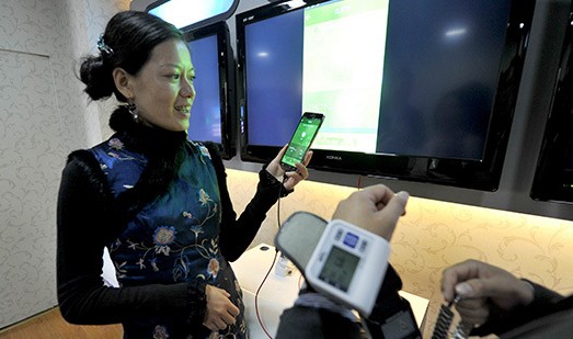    图为血压监测器和手机相连，测出血压后会发短信告知你的血压情况。
